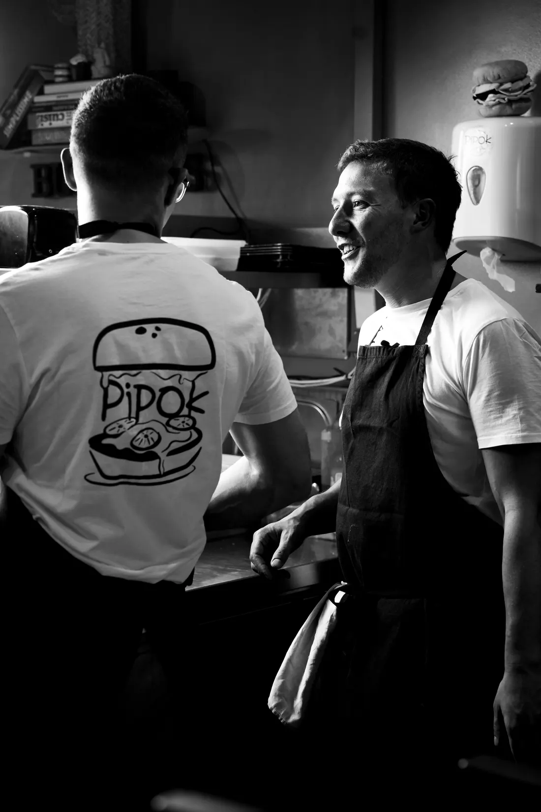Les deux gérants de Pipok en cuisine, t-shirt au logo Pipok, en pleine discussion pendant le service