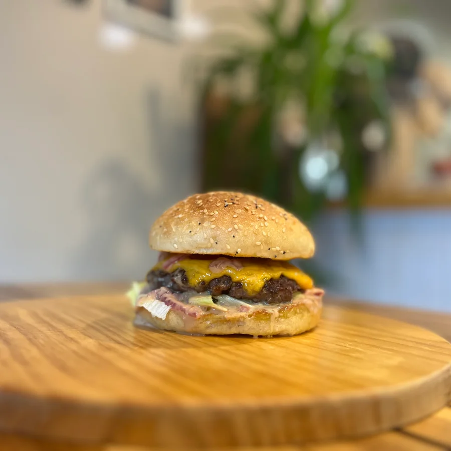 Cheeseburger maison sur planche en bois, pain aux graines — Pipok